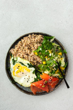 Delicious healthy breakfasts, green buckwheat with fried egg and spinach and red salmon fish, mix salad with fresh herbs and peppers and seeds, healthy balanced breakfast with fats, fiber and proteinの写真素材