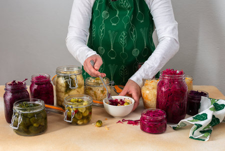 Fermenting different cabbages, white and red cabbage, Brussels and cauliflower, broccoli, woman fermenting sauerkrautの写真素材