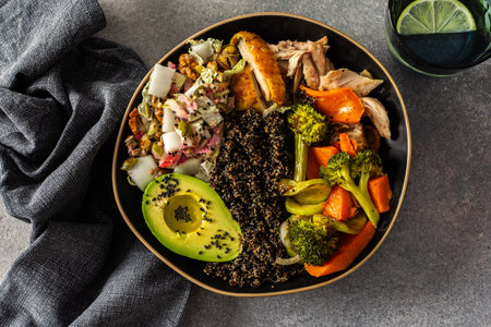 Nutritious, wholesome breakfast featuring quinoa, avocado, roast chicken, and roasted vegetables like sweet potato, zucchini, and broccoli, complemented with a fresh cabbage and radish saladの写真素材