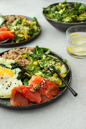 Delicious healthy breakfasts, green buckwheat with fried egg and spinach and red salmon fish, mix...