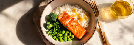 A vibrant bowl filled with salmon, rice, broccoli, and edamame is presented in a bright kitchen, showcasing a stylish and nutritious meal under warm sunlight., bannerの素材