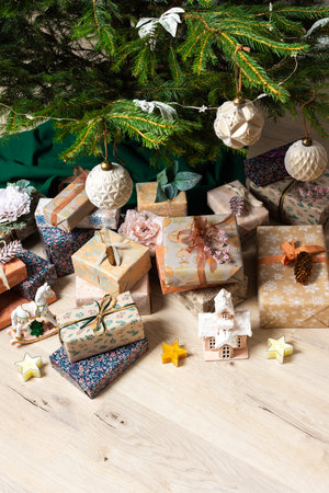 A cozy Christmas scene with elegant natural-toned gift boxes placed under a Christmas tree, lit with festive lights evoking peace and seasonal joyの写真素材