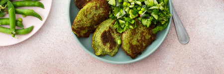 Enjoy zucchini and broccoli pancakes paired with a fresh mixed salad featuring cucumbers, young peas, and radishes. A delicious and healthy vegetarian meal , bannerの写真素材