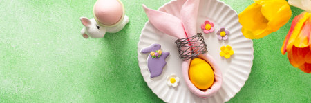 A beautifully arranged Easter table setting showcases a decorative egg nestled in a pink napkin,...