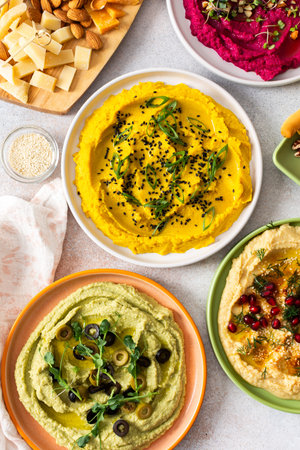 A variety of hummus flavors including turmeric, classic, and broccoli are served with fresh bread,...