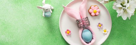 A beautifully arranged table setting for Easter features a pink napkin wrapped around an egg,...