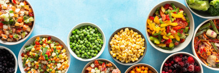 A variety of fresh vegetables frozen for winter, arranged on plates against a cool blue background, showcasing vibrant, seasonal produce ready for future meals, bannerの写真素材