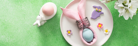 A beautifully arranged table setting for Easter features a pink napkin wrapped around an egg,...