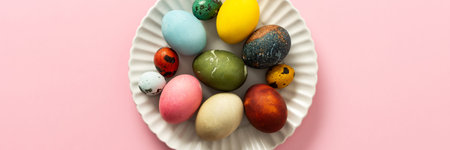 A collection of vibrant Easter eggs in various colors is artfully arranged on a white plate, set...