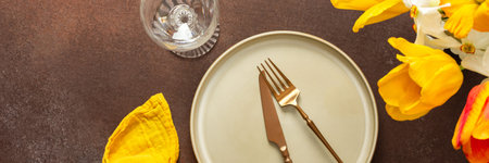 A beautifully arranged spring table setting features a light plate, gold-tone utensils, and vibrant...