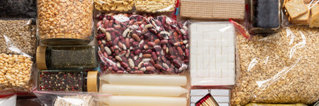 Home food supplies for quarantine and isolation, including canned food, cereals, pasta, and essential staples for survival, the concept of stay at home, bannerの写真素材