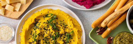 A variety of hummus flavors including turmeric, classic, and broccoli are served with fresh bread,...