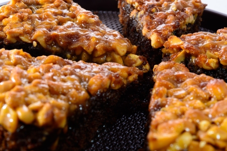 CHOCOLATE BROWNIES TOPPING WITH CASHEW NUTS ON THE BROWN CIRCLE PLASTIC TRAYの写真素材