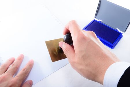 HAND IN SUIT STAMPING ON PAPER WITH WHITE ISOLATED BACKGROUNDの写真素材