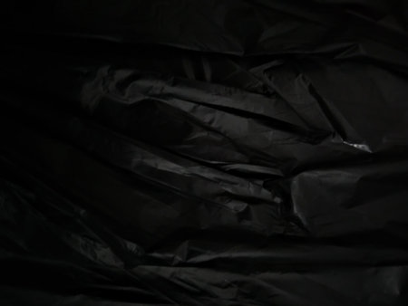 Black crumpled plastic bag as background, close-up.の写真素材
