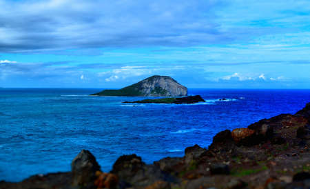 Vivid blue waters with small islandの写真素材