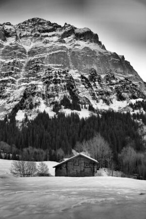 Cabin in snow with mountainの写真素材