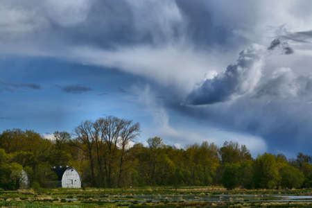 Stormy clouds with white barnの写真素材