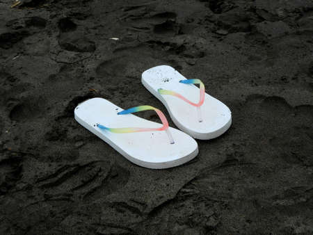 Flip flops on dark sandの写真素材