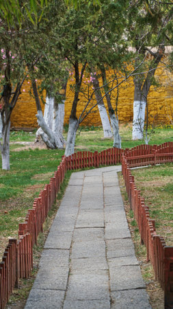 Stone way in the garden with red fence