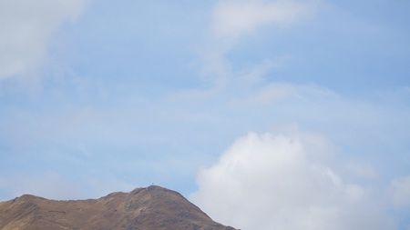 Mountain peak with some clouds and clear blue skyの写真素材