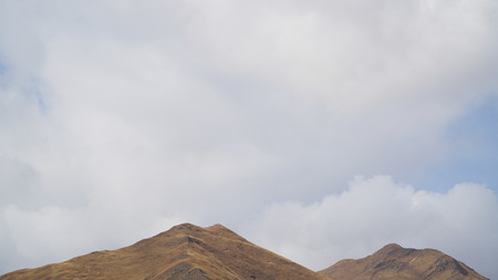 Mountain peak with some clouds and clear blue skyの写真素材