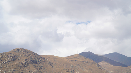 Mountain peak with some clouds and clear blue skyの写真素材