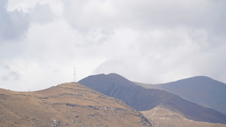 Mountain peak with some clouds and clear blue skyの写真素材