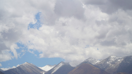 Mountain peak with some clouds and clear blue skyの写真素材