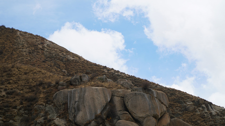 Mountain peak with some clouds and clear blue skyの写真素材