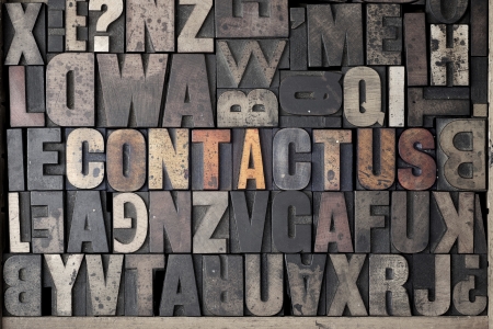 The words Contact Us written out in very old and worn letterpress typeの写真素材