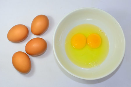 egg yolk and white in a white bowl