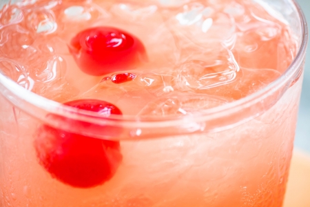 Glass of mix fruits juice soda with cherry up closeの写真素材