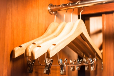 Wooden hanger hanging in a wood closetの写真素材