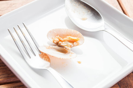 Stir fried roasted chili paste clam on white dish with spoon and fork