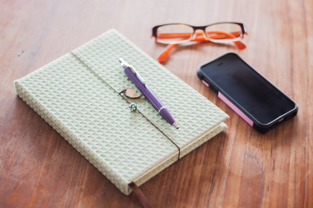 Notebook and pen on wooden table, stock photoの写真素材
