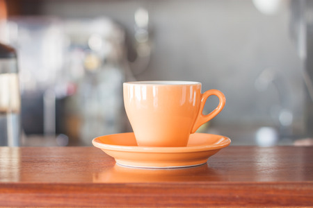 Orange coffee cup in coffee shop, stock photoの写真素材