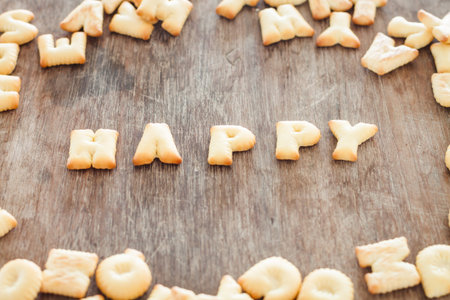 Happy alphabet biscuit on wooden table, stock photo