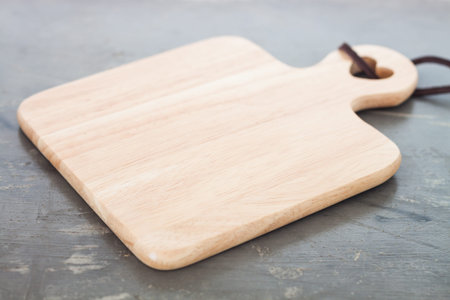 Wooden plate on gray background, stock photo