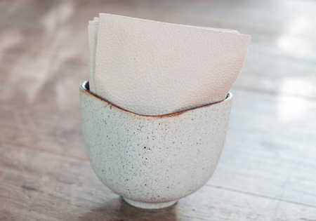 Tissue paper in ceramic cup on wooden table, stock photoの写真素材