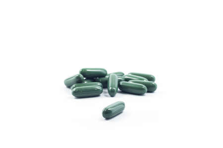 Green capsule pills on white background, stock photoの写真素材