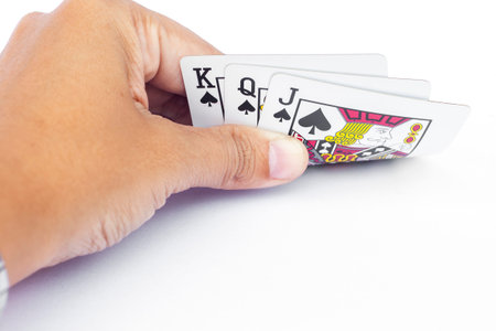 Playing cards in hand isolated on white background, stock photo