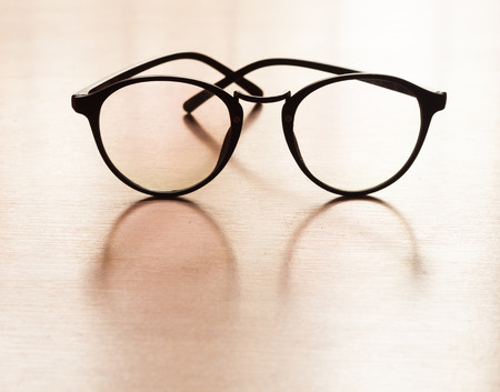 Eyeglasses with reflection on wooden tableの写真素材