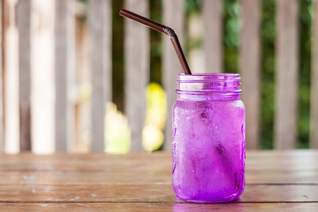 Iced drink in violet glass in coffee shop, stock photoの写真素材