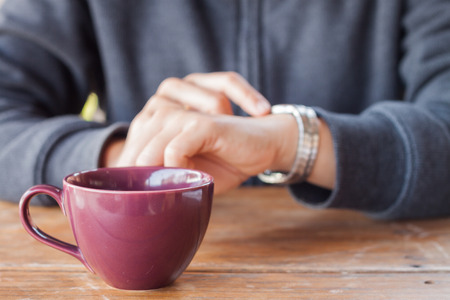 Woman checks the time on a wrist watch, stock photoの写真素材