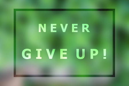 Never give up inspirational quote on blurred backgroundの写真素材