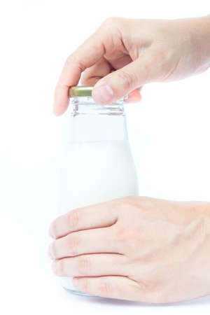 Woman hand open traditional glass milk bottle, stock photoの写真素材