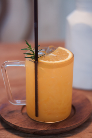 Glass of fresh orange juice with slice on wooden tableの写真素材