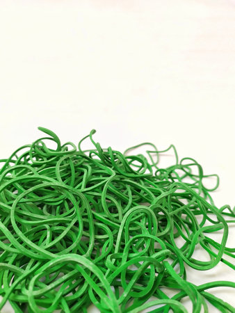 Green rubber bands on a white background. Close-up, selective focus.の写真素材