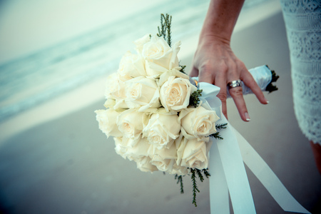 Bride hands on yellow flowersの写真素材